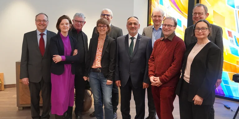 Eine Gruppe von Menschen guckt in die Kamera.