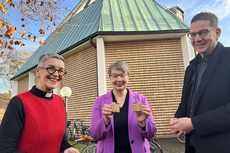 Drei menschen vor einer Kirche