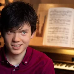 Der junge Organist Julian Emanuel Becker vor dem Spieltisch einer Orgel