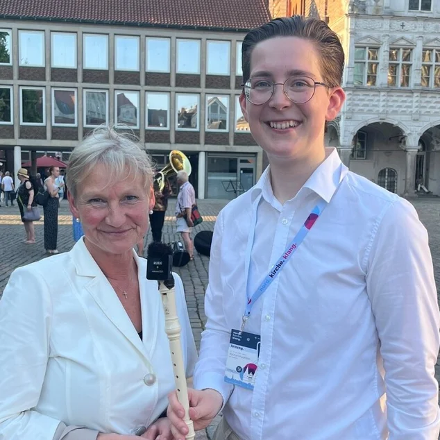 Eine Frau und ein Mann stehen auf einem Marktplatz.