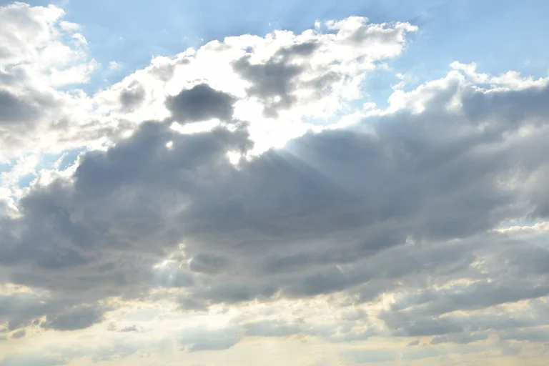 Sonne hinter Wolken mit blauem Himmel