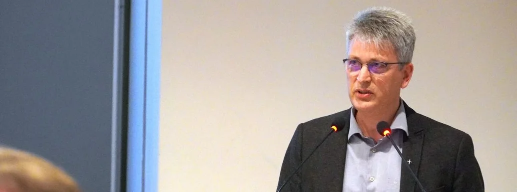 Ein Mann steht an einem Vortragspult-