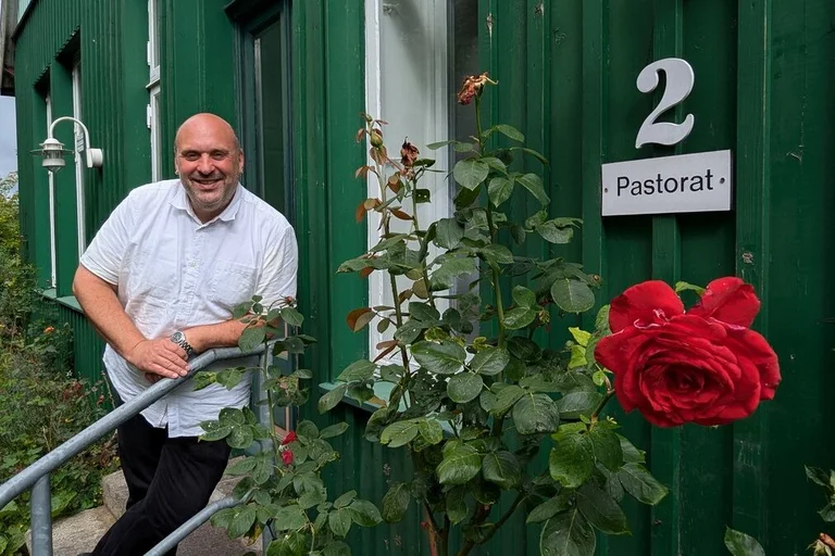 Ein Mann steht vor einem Haus