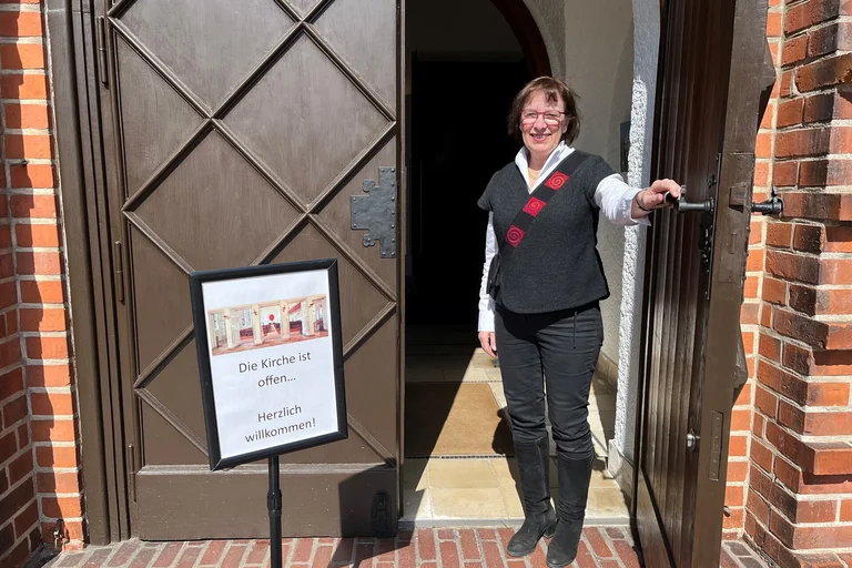 Eine Frau steht in einer Kirchentür 