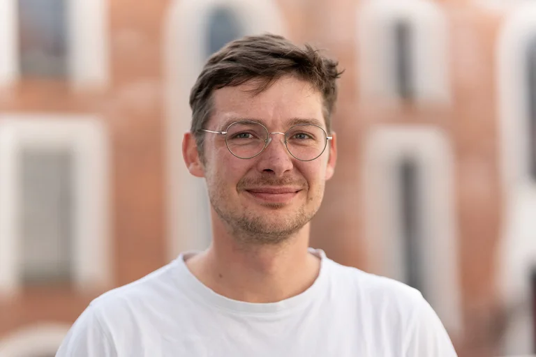 Junger Mann lächelt in die Kamera