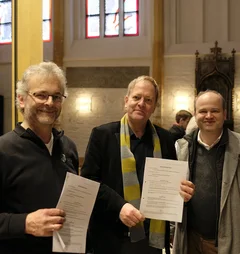 Gruppenfoto mit drei Männern in einer Kirche