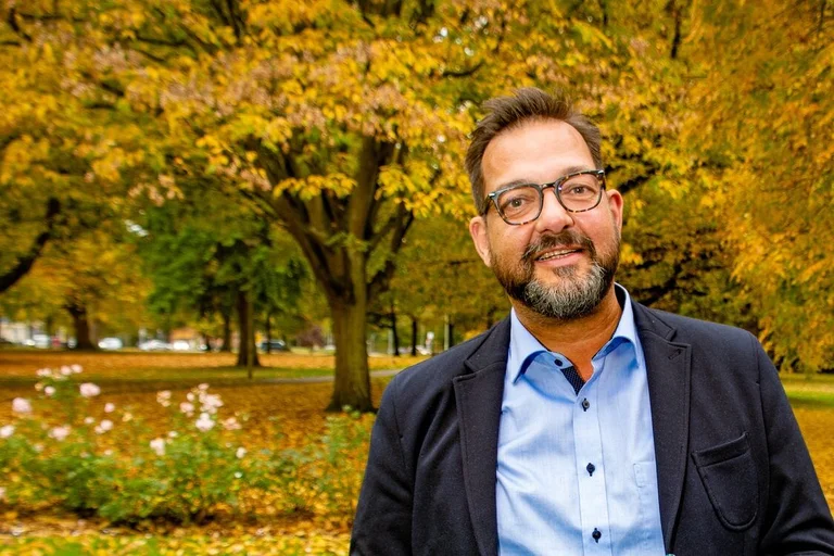 Ein Mann steht in einer herbstlichen Kulisse