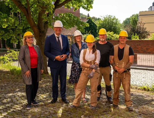 Mehrere Personen mit Bauhelmen auf einem Gruppenbild