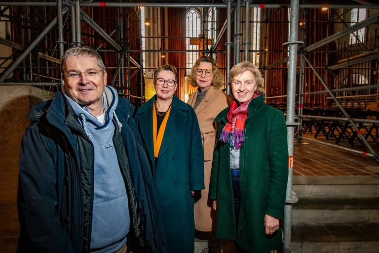 Vier Personen stehen in einer Kirche