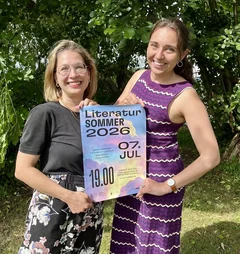 Zwei Frauen halten ein Plakat fest