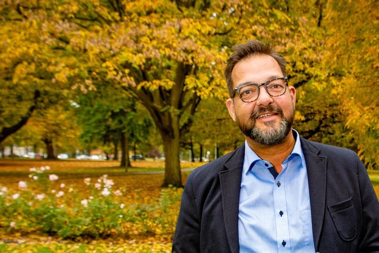 Ein Mann steht in einer herbstlichen Kulisse