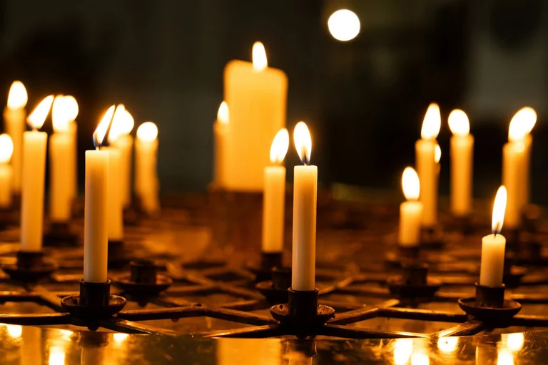 Mehrere brennende Kerzen im Dunkeln.