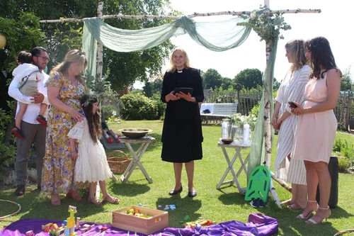 Tauffamilie mit Pastorin im Garten