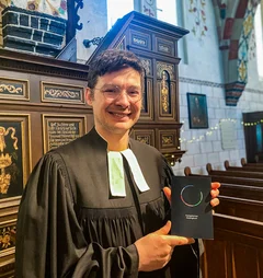 Ein Pastor mit einem Gesangbuch in einer Kirche 