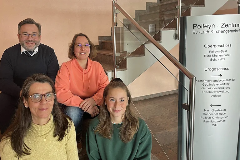 Vier Personen sitzen auf einer Treppe