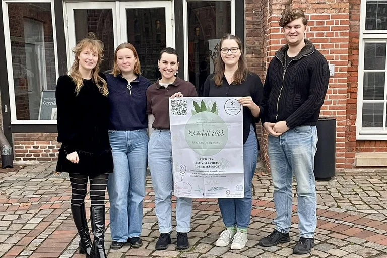 Menschen mit einem Plakat stehe vor einem Gebäude