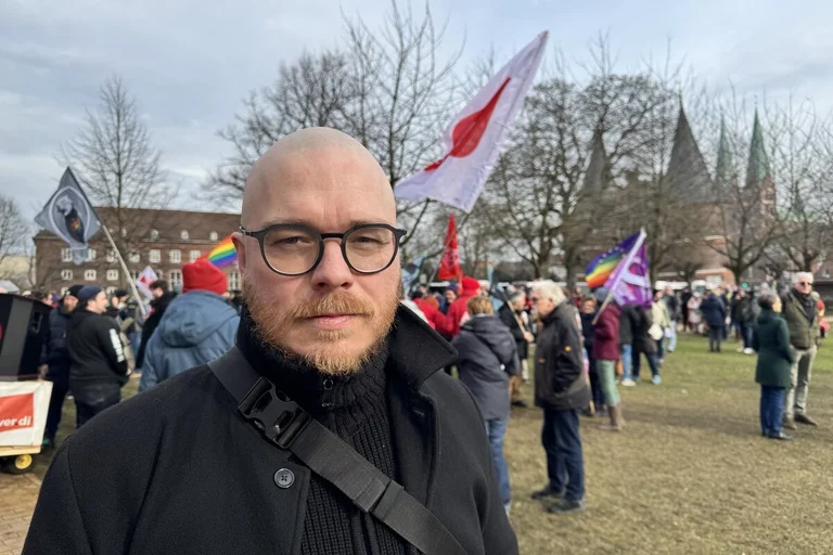 Menschen demonstrieren in Lübeck - ein Mann blickt in die Kamera