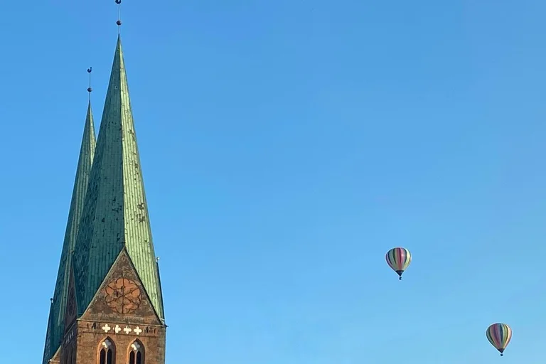 Turn einer Kirche mit zwei Heißluftballons