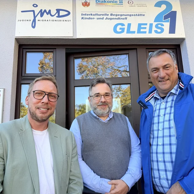 Drei Männer schauen in die Kamera