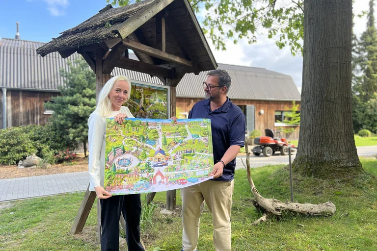 Zwei Personen stehe mit einem Plakat vor einem Schaukasten