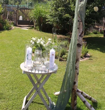 Stehtisch mit Blumen und Kerzen der Gartentaufe