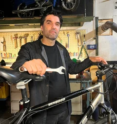 Mann steht an einem Fahrrad