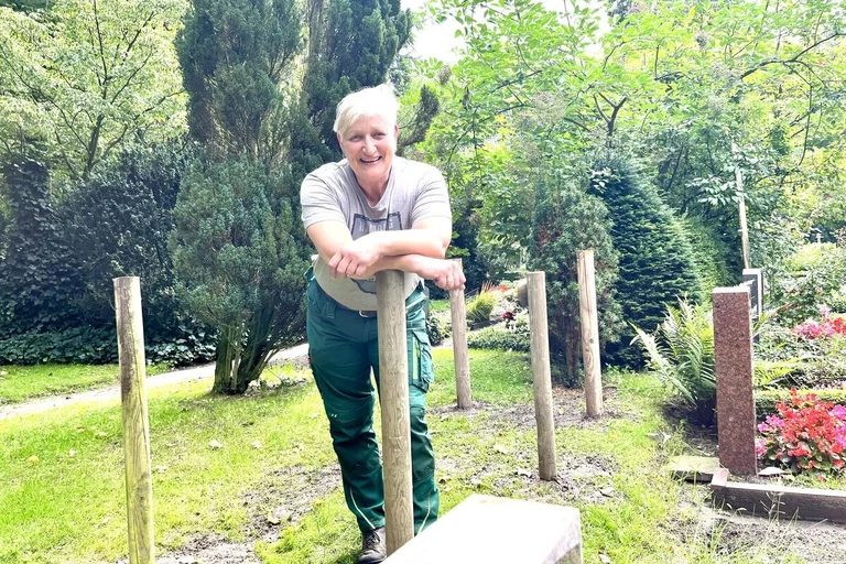 Eine Frau steht auf einem Friedhof