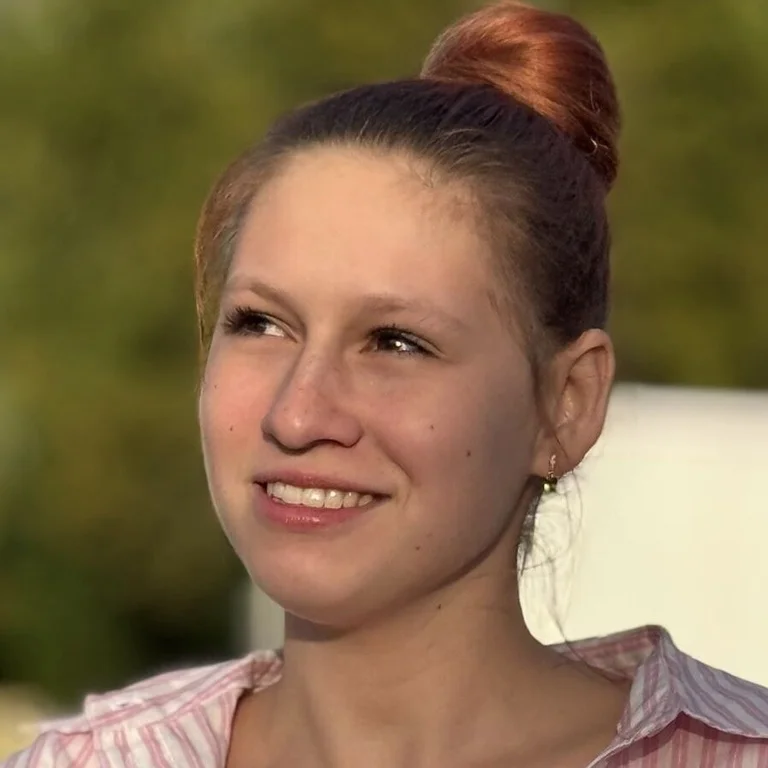 Eine Frau mit Pferdeschwanz lächelt