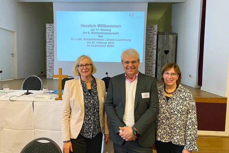 Drei Personen schauen in die Kamera