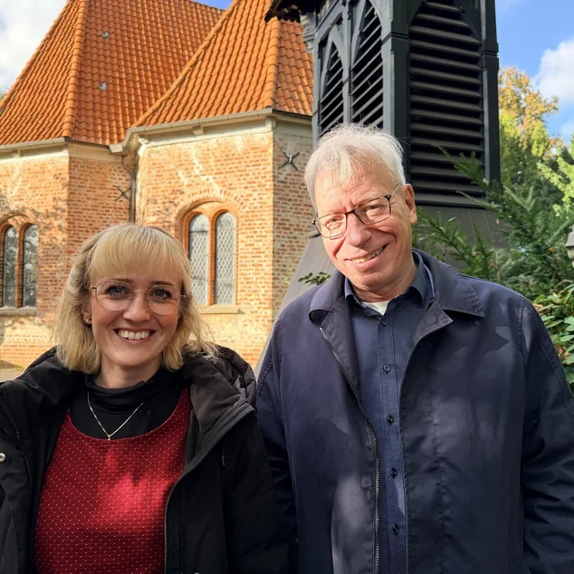 Zwei Menschen stehen vor einer Kirche 