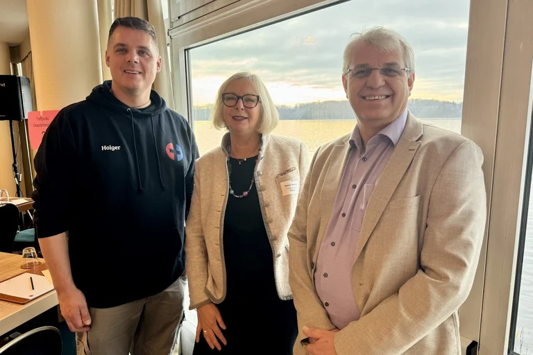 Drei Personen schauen in die Kamera