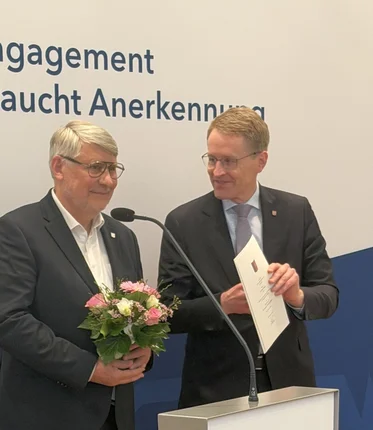 Zwei Männer stehen vor einem Mikrofon.
