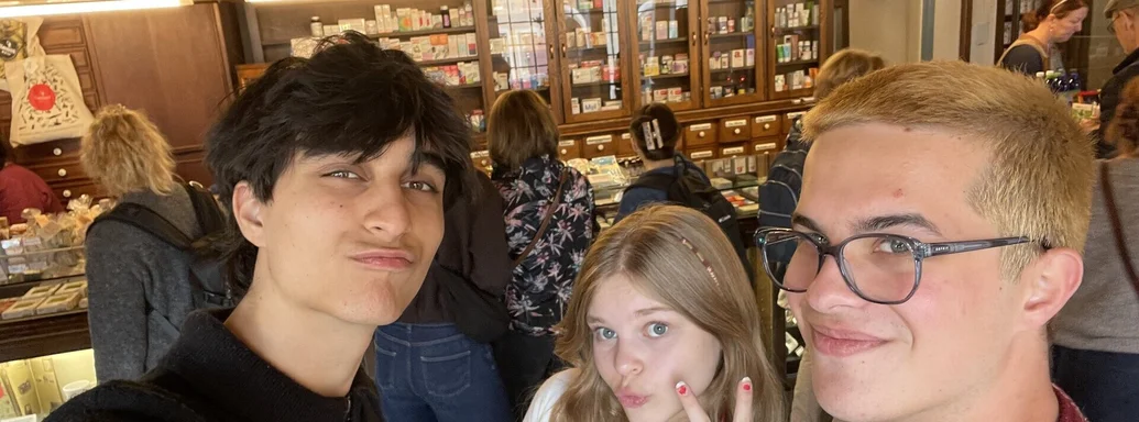 Drei junge Menschen gucken verschmitzt in die Kamera.