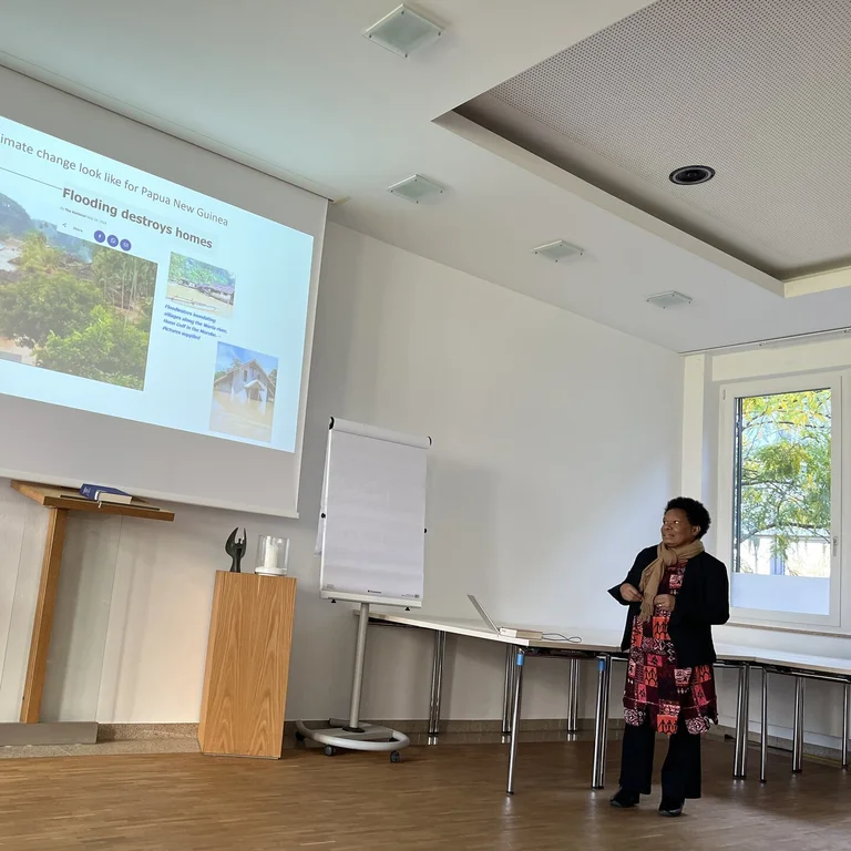 Eine Frau steht vor einer Leinwand mit einer Präsentation