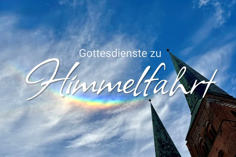 Die Türme des Lübecker Domas mit einem kleinen Regenbogen am Himmel