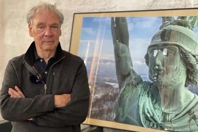 Fotograf Harald Schmitt steht vor seinem Foto des das Hermannsdenkmals bei Detmold, das gleich am Anfang der Ausstellung zu sehen ist. 