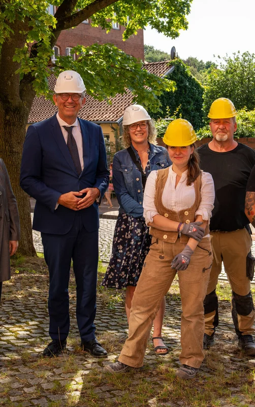 Mehrere Personen mit Bauhelmen auf einem Gruppenbild
