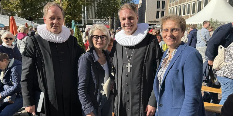 Zwei Männer im Pastorenornat und zwei Frauen im Gruppenbild