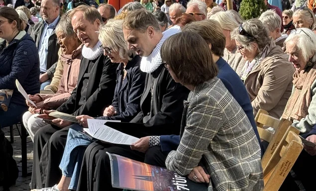 Menschen auf Stühlen beim Singen 