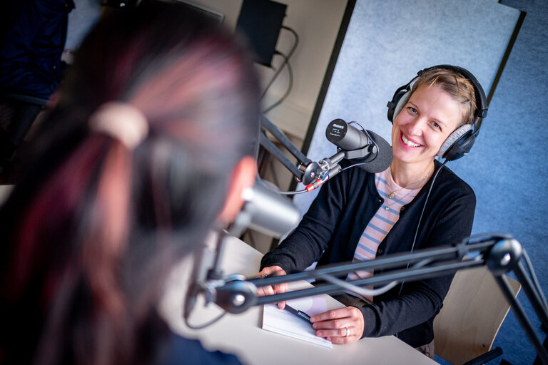 Zwei Frauen sitzen an Mikrofonen in einem Studio.