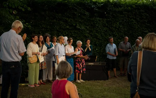 Eine Gruppe Menschen auf einem Friedhof im Abendlicht