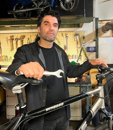 Mann steht an einem Fahrrad