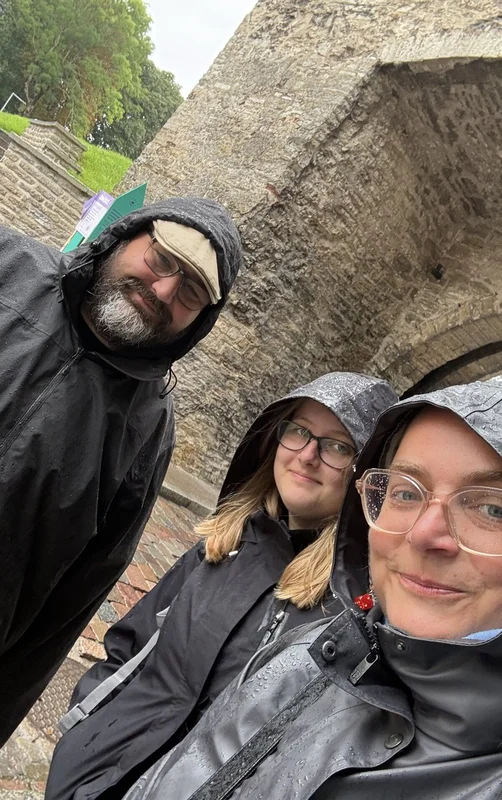 Drei Menschen mit Regenkapuzen