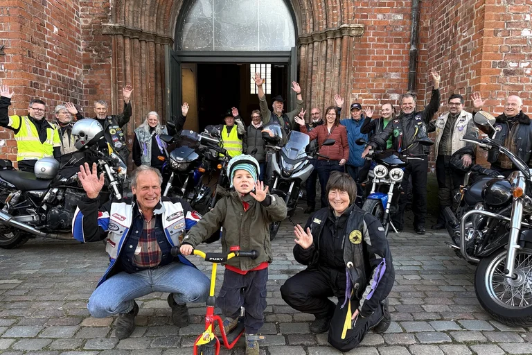 Menschen vor einer Kirche winken