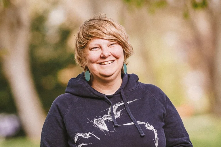 Frau lacht freundlich in die Kamera.