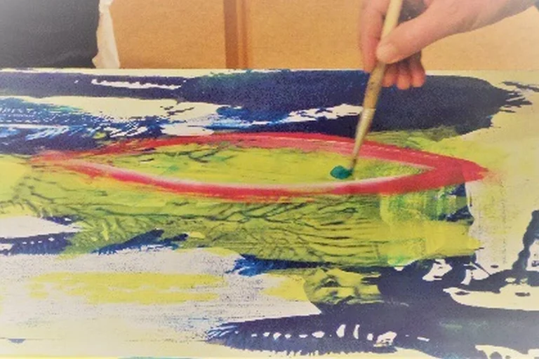 Hand hält Pinsel und malt