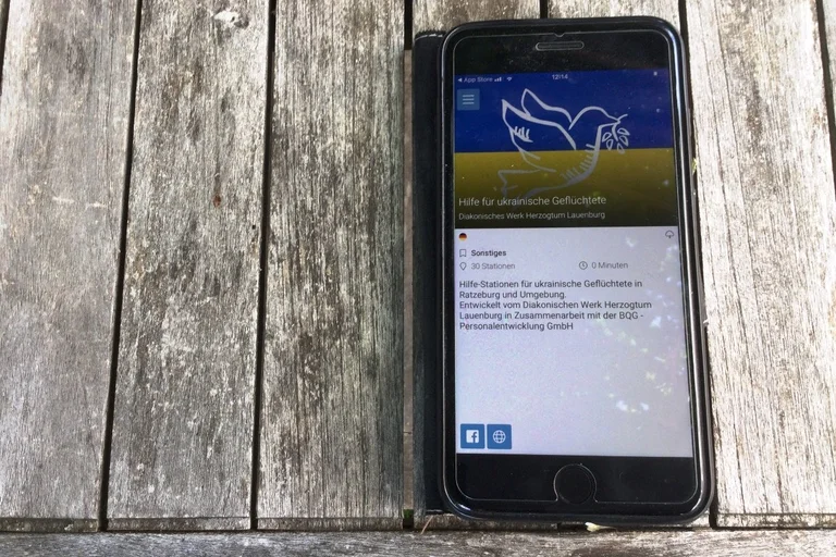 Ein Handy mit der Startseite der Willkommens-App für ukrainische Geflüchtete