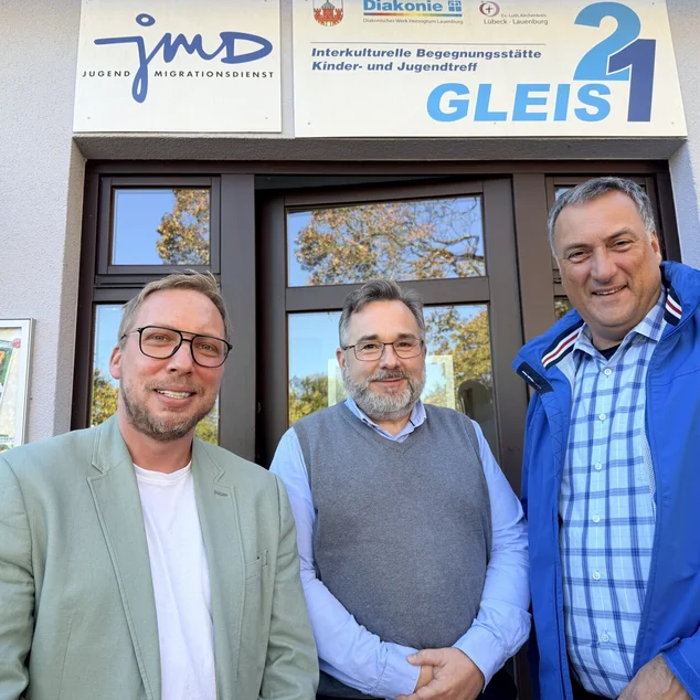 Drei Männer vor einem Gebäude