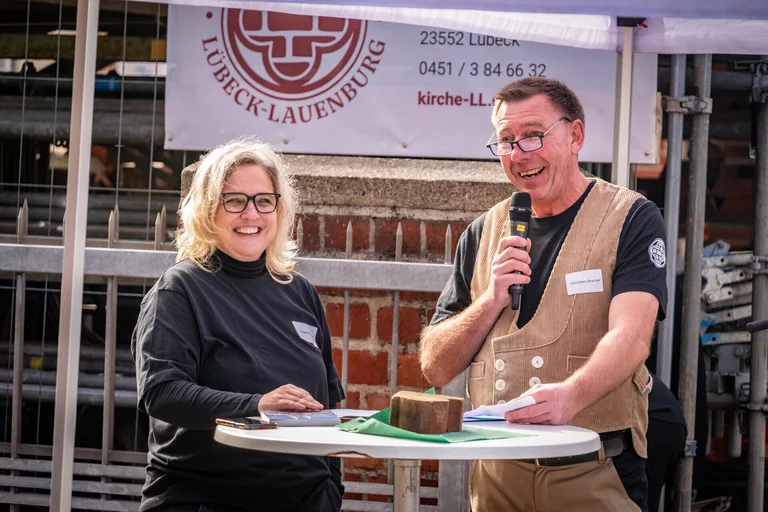 Eine Frau und ein Mann stehen an einem Stehtisch.