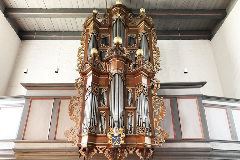 Eine Orgel auf einer Empore, die Orgelpfeifen sind zu sehen